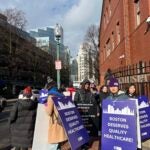 Supporters march down the street holding signs