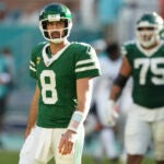 Aaron Rodgers walks off the field after failing to convert on third down during a game against the Dolphins.