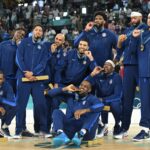 Gold medallists (From L) USA's #04 Stephen Curry, USA's #07 Kevin Durant, USA's #05 Anthony Edwards, USA's #09 Tyrese Haliburton, USA's #08 Derrick White, USA's #10 Jayson Tatum, USA's #06 LeBron James, USA's #11 Joel Embiid, USA's #13 Bam Adebayo, USA's #14 Anthony Davis, USA's #15 Devin Booker and USA's #12 Jrue Holiday pose on the podium after the men's Gold Medal basketball match between France and USA during the Paris 2024 Olympic Games at the Bercy Arena in Paris on August 10, 2024. (Photo by Damien MEYER / AFP)