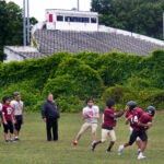 Boston Latin football coach Rocco Zizza watches his team practice on the field outside White Stadium.