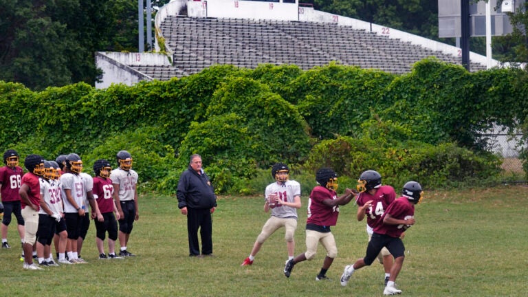 Boston Latin football coach Rocco Zizza watches his team practice on the field outside White Stadium.