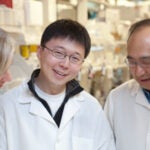 MIT professor and brain researcher Feng Zhang, center, co-founder of Editas Medicine, stands with colleagues as the company announces plans to lay off approximately 180 employees.