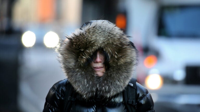 A woman is bundled for the cold outside on Essex Street in Boston.