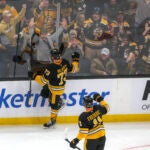 Boston Bruins defenseman Charlie McAvoy (73) celebrates his goal with teammate Trent Frederic (11) and the fans against the Montreal Canadians during first period NHL action at TD Garden.