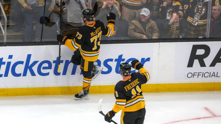 Boston Bruins defenseman Charlie McAvoy (73) celebrates his goal with teammate Trent Frederic (11) and the fans against the Montreal Canadians during first period NHL action at TD Garden.