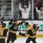 Boston Bruins center Charlie Coyle (13) celebrates his goal with teammates Brad Marchand.(63) and Elias Lindholm (28) against the Washington Capitals during third period NHL action at TD Garden.