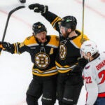 Boston Bruins forward Justin Brazeau (55) celebrates his goal with teammate David Pastrnak (88) in front of Washington Capitals right wing Brandon Duhaime (22) during first period NHL action at TD Garden.