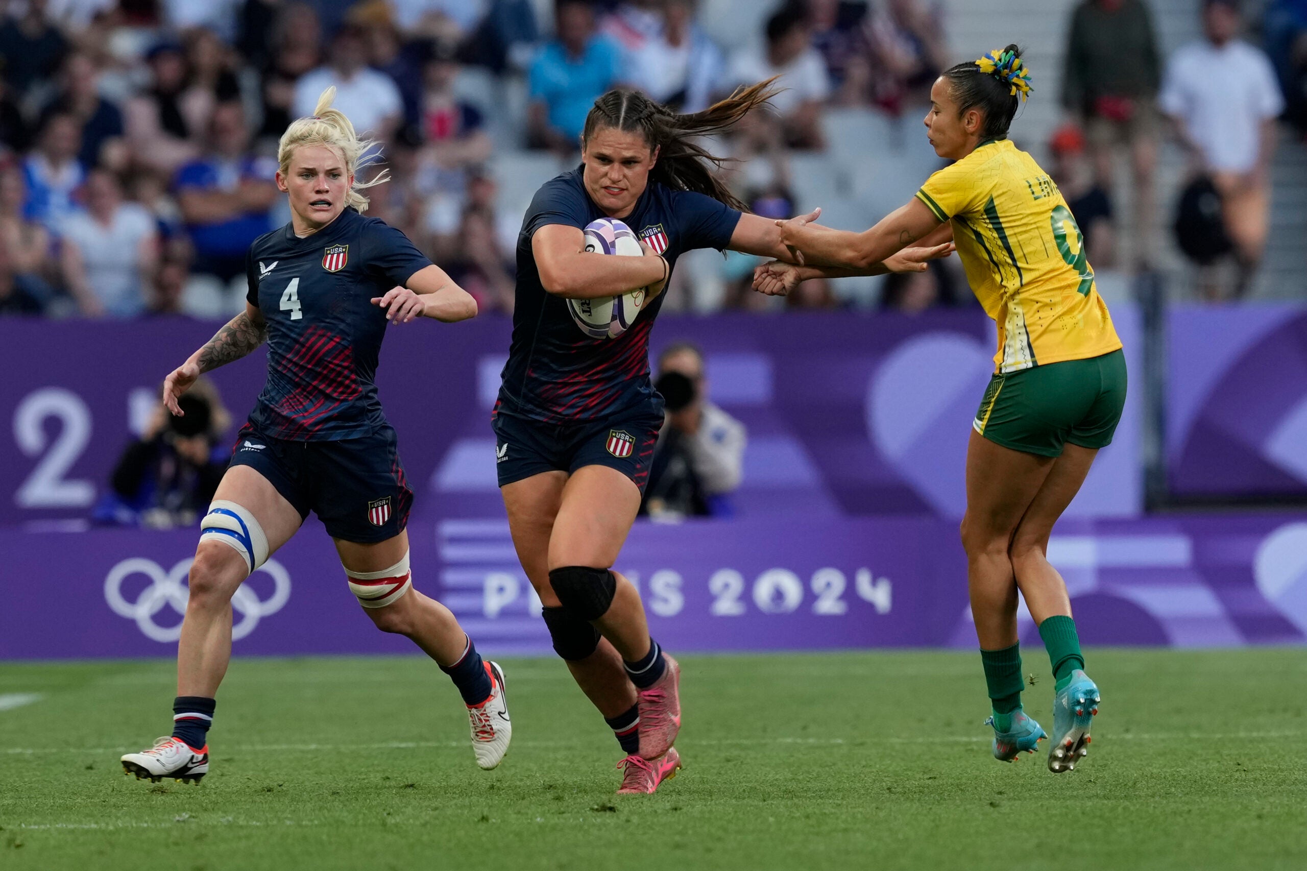 United States' Ilona Maher, center, gets past the tackle of Brazil's Gabriela Lima.