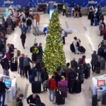 Holiday travelers wait in line to check their bags at the JetBlue terminal at Logan Airport.