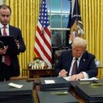 President Donald Trump signs an executive order.