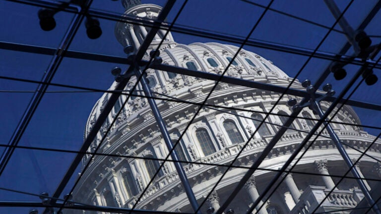 The Capitol dome on Capitol Hill is seen through a glass structure.