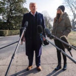First lady Melania Trump looks on as President Donald Trump speaks with reporters.