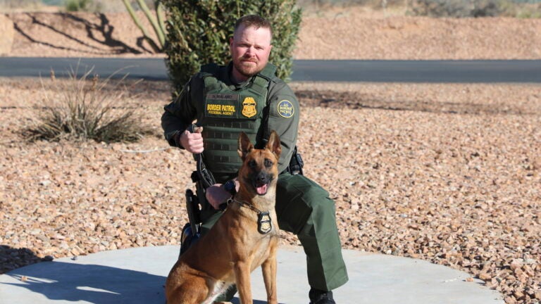 Border Patrol Agent David Maland posing with a service dog.