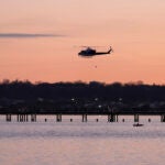 A helicopter flies over the Potomac River near Ronald Reagan Washington National Airport.