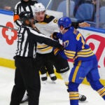 Boston Bruins defenseman Nikita Zadorov (91) and Buffalo Sabres right wing JJ Peterka (77) are separated by a linesman during the third period of an NHL hockey game Tuesday, Jan. 28, 2025, in Buffalo, N.Y.