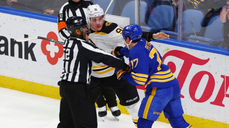 Boston Bruins defenseman Nikita Zadorov (91) and Buffalo Sabres right wing JJ Peterka (77) are separated by a linesman during the third period of an NHL hockey game Tuesday, Jan. 28, 2025, in Buffalo, N.Y.