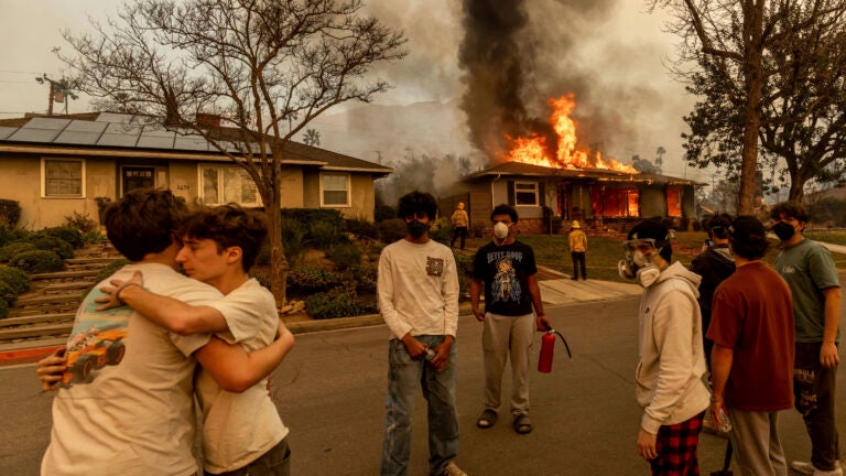 Residents embrace outside of a burning property.