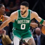 Boston Celtics forward Jayson Tatum (0) dribbles as Oklahoma City Thunder forward Jalen Williams (8) defends during the second half of an NBA basketball game Sunday, Jan. 5, 2025, in Oklahoma City.