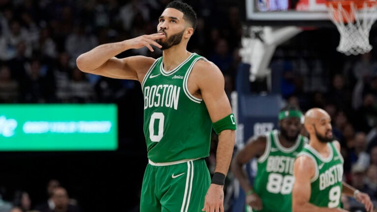 Celtics forward Jayson Tatum gestures after making a 3-point shot during the first half.