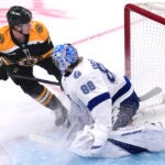 Boston Bruins center Trent Frederic flips the puck past Tampa Bay Lightning goaltender Andrei Vasilevskiy for a goal during the first period.
