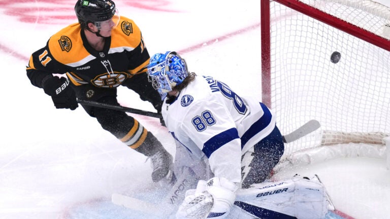 Boston Bruins center Trent Frederic flips the puck past Tampa Bay Lightning goaltender Andrei Vasilevskiy for a goal during the first period.