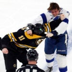 Boston Bruins center Trent Frederic (11) and Tampa Bay Lightning defenseman Emil Lilleberg (78) fight in the second period at TD Garden.
