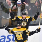 Bruins center Charlie Coyle (celebrates with defenseman Nikita Zadorov after scoring in the third period.
