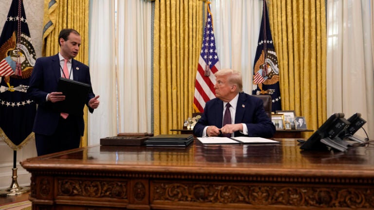 President Donald Trump talks with White House staff secretary Will Scharf as he signs executive orders in the Oval Office of the White House, Thursday, Jan. 23, 2025, in Washington.