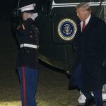President Donald Trump greets a Marine Corps honor guard as he disembarks Marine One upon arrival on the South Lawn of the White House in Washington, Monday, Jan. 27, 2025.