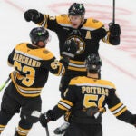 Boston Bruins center Charlie Coyle (13) celebrates his goal with teammates Brad Marchand (63) and Matthew Poitras (51) against the San Jose Sharks during third period NHL action at TD Garden.