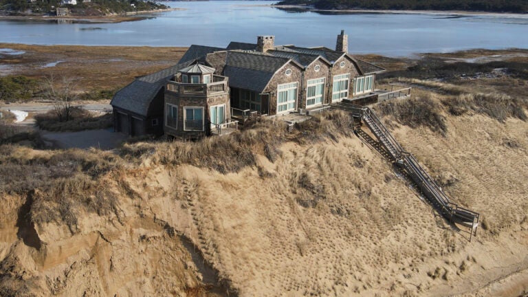 The house sits on a chunk of sand overlooking the beach at Wellfleet.