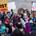 Sen. Elizabeth Warren, D-Mass., accompanied by other members of congress, speaks to the crowd during a rally against Elon Musk.