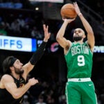 Celtics guard Derrick White shoots over Cleveland Cavaliers guard Max Strus, center, in the second half.