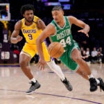 Boston Celtics guard Jaden Springer, right, drives by Los Angeles Lakers guard Bronny James during the second half of an NBA basketball game, Thursday, Jan. 23, 2025, in Los Angeles.