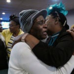 Marie Guillou, front left, hugs and worships with a fellow congregant at the First Haitian Evangelical Church of Springfield, Sunday, January 26, 2025, in Springfield, Ohio.