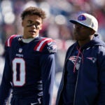New England Patriots cornerback Christian Gonzalez (0) talks with coach Matthew Slater prior to an NFL football game, Sunday, Oct. 27, 2024, in Foxborough, Mass.