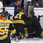 Bruins center Matthew Poitras was injured after being checked into the Islanders open bench door in the 2nd period.