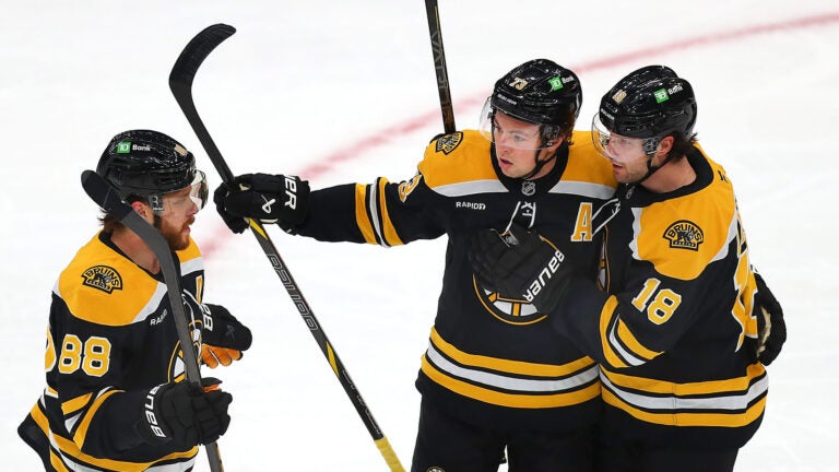 Boston Bruins defenseman Charlie McAvoy (73) (center) is congratulated by Boston Bruins center Pavel Zacha (18) (right) and Boston Bruins right wing David Pastrnak (88) after his 1st bperiod goal.