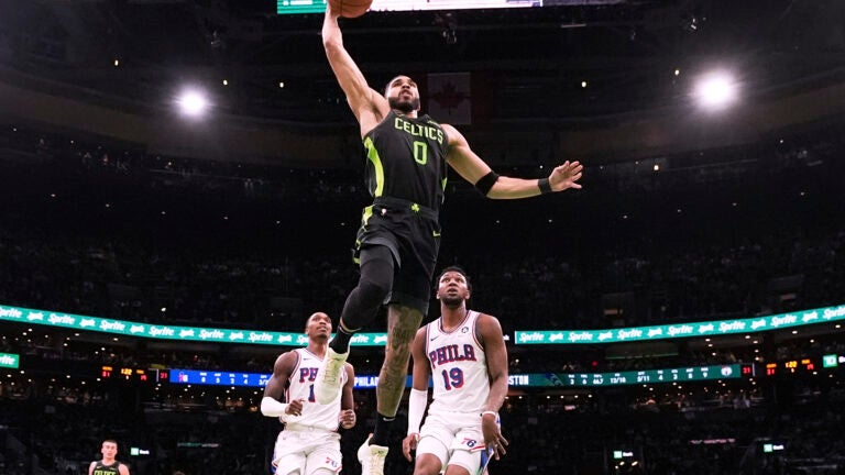 Celtics forward Jayson Tatum drives to the basket on a dunk against the Philadelphia 76ers during the first half.