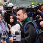 Members of the Columbia University Apartheid Divest group, including Sueda Polat, second from left, and Mahmoud Khalil, center, are surrounded by members of the media outside the Columbia University campus.