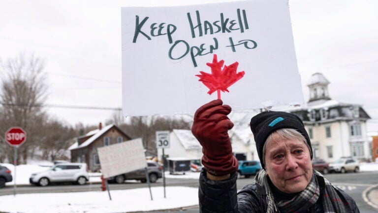 Penny Thomas who drove from Newport, Vt., has a tear roll down her cheek as she holds a sign.