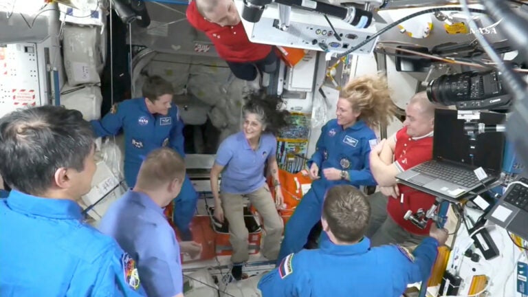 This image made from video by NASA shows astronauts, including Suni Williams, center, greeting each other after a SpaceX capsule docked with the International Space Station, Sunday, March 16, 2025.