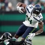 EAST RUTHERFORD, NEW JERSEY - DECEMBER 01: DK Metcalf #14 of the Seattle Seahawks carries the ball as Qwan'tez Stiggers #37 of the New York Jets defends at MetLife Stadium on December 01, 2024 in East Rutherford, New Jersey.