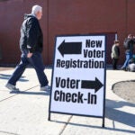 A sign for new voter registration is seen outside a polling location at Pinkerton Academy in Derry, N.H., Tuesday, March 11, 2025.