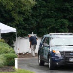 An investigator sifts through dirt