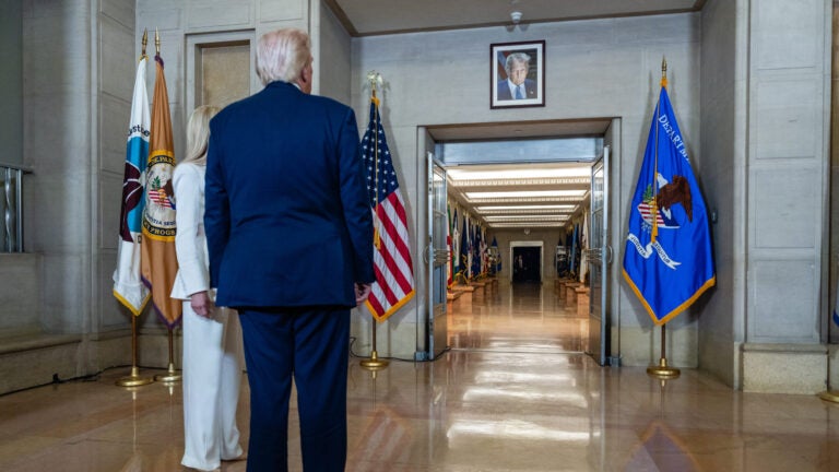President Donald Trump pauses to view his official portrait hanging in the hallway.