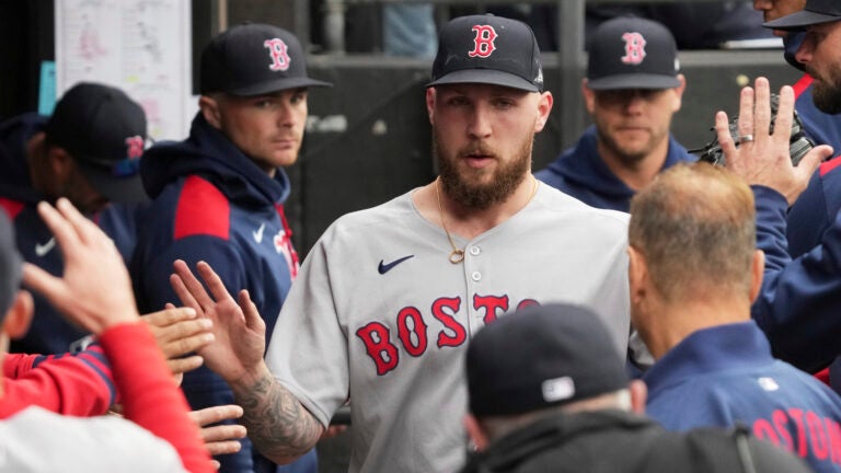 Boston Red Sox starting pitcher Garrett Crochet is congratulated by teammates in the dugout during the eighth inning of a baseball game against the Chicago White Sox in Chicago, Sunday, April 13, 2025.