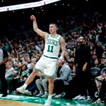 Boston Celtics guard Payton Pritchard (11) signals his three pointer from the corner is good during the fourth quarter in game one of the NBA Eastern Conference playoffs against the Orlando Magic at TD Garden.