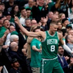 Boston Celtics center Kristaps Porzingis (8) celebrates with fans after drawing a foul during the second quarter in game two of the NBA Eastern Conference playoffs against the Orlando Magic at TD Garden.