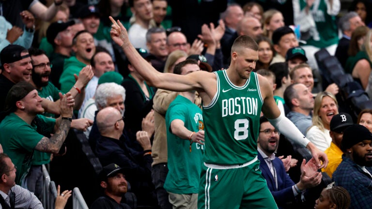 Boston Celtics center Kristaps Porzingis (8) celebrates with fans after drawing a foul during the second quarter in game two of the NBA Eastern Conference playoffs against the Orlando Magic at TD Garden.